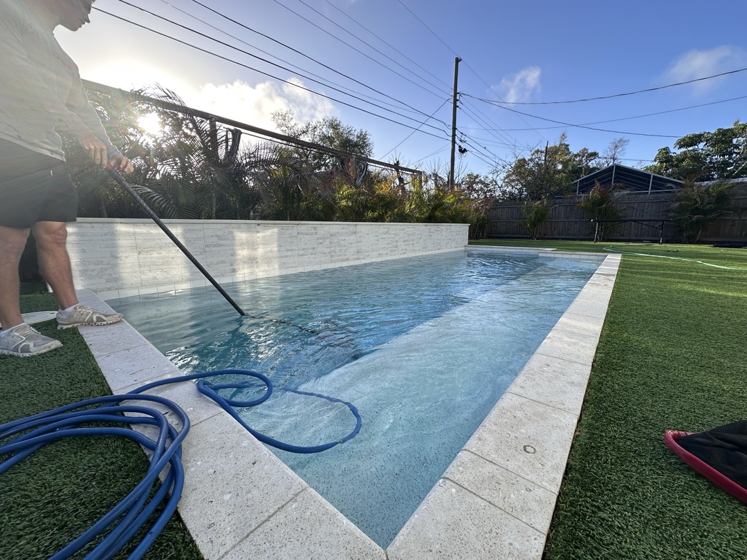 Sunshine Pool Group technician vacuuming a residential pool in Pinellas County, FL